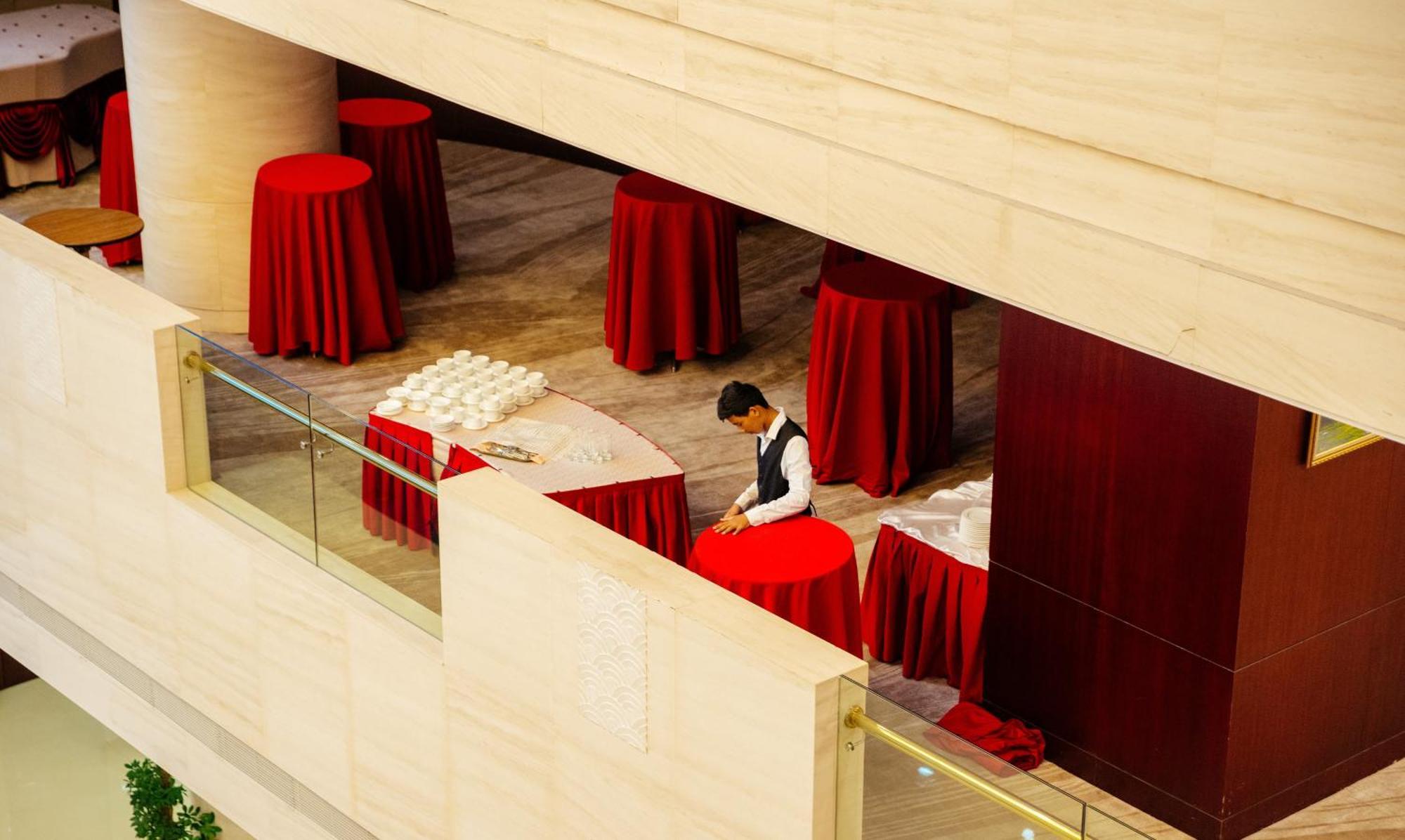 Beijing Palace Soluxe Hotel Astana Exterior photo A hotel staff sets up a cocktail reception